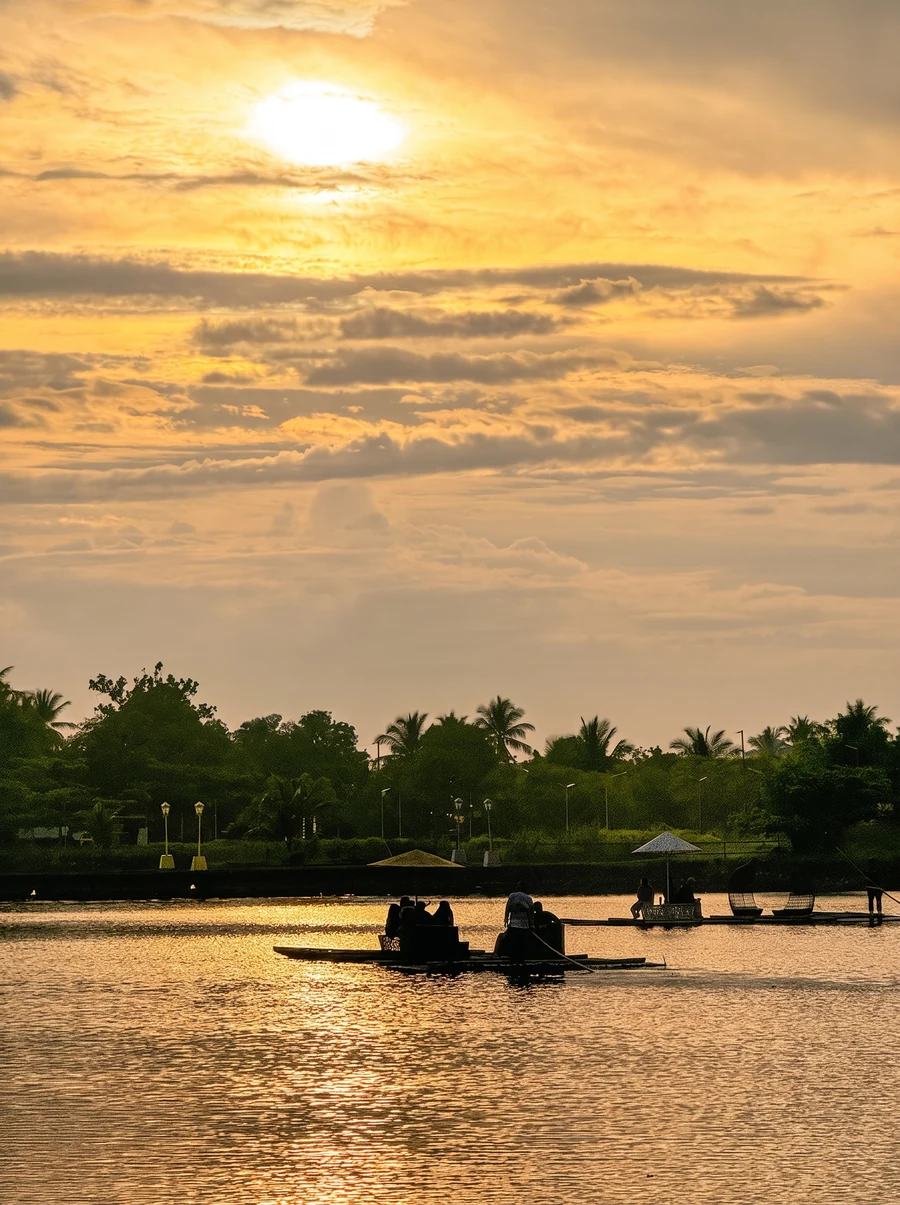 Atardecer sobre el río en Camarines Sur, con balsas y palmeras a contraluz