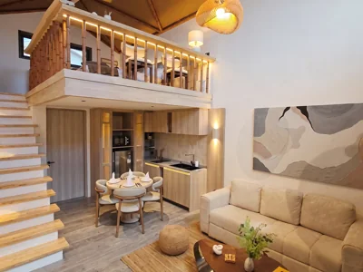 Salón de doble altura de una eco villa de Land of Nomads en San Fernando, con cocina y altillo