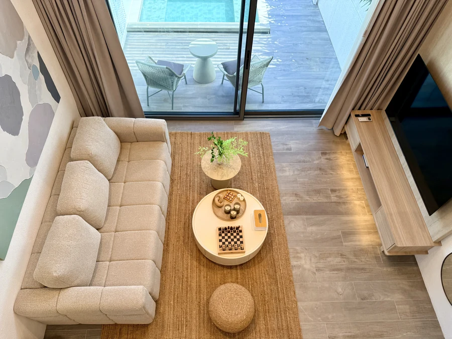 Living room of a Premium Villa seen from the mezzanine, with the private pool beyond