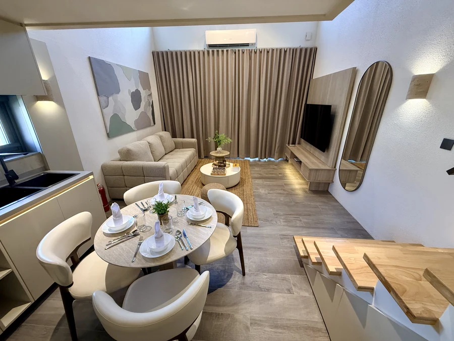Living and dining area of a finished Premium Villa, table set and kitchen behind
