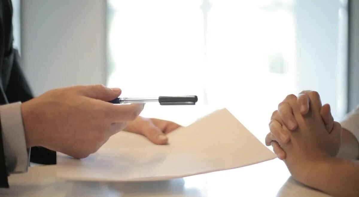 Manos firmando un contrato de derecho de uso sobre una mesa de madera con documentos legales filipinos