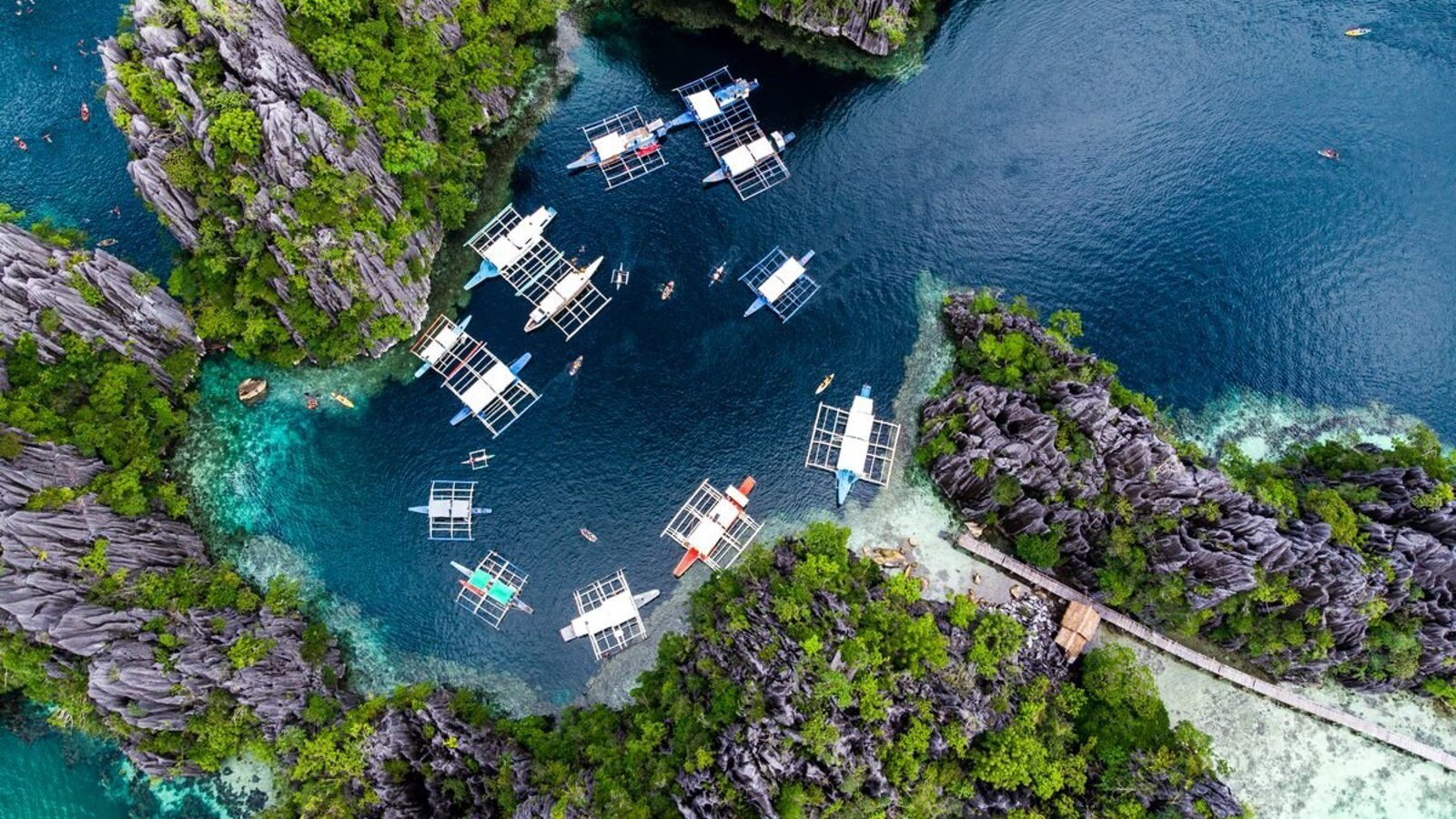 Laguna de Caramoan desde el aire, con una docena de barcas bangka fondeadas entre paredes de karst cubiertas de vegetación