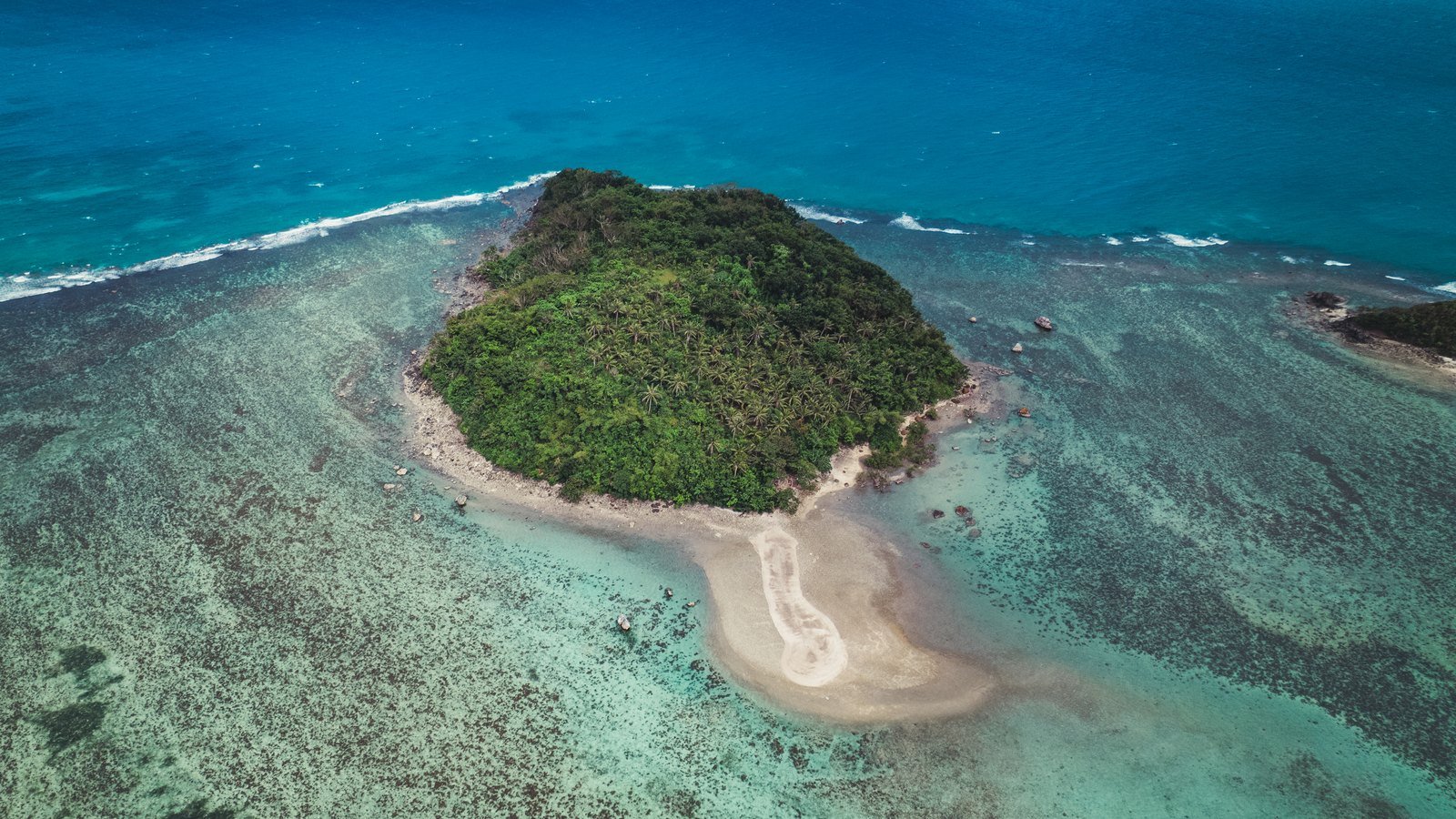 Isla con palmeras y arrecife en aguas de Filipinas vista desde el aire