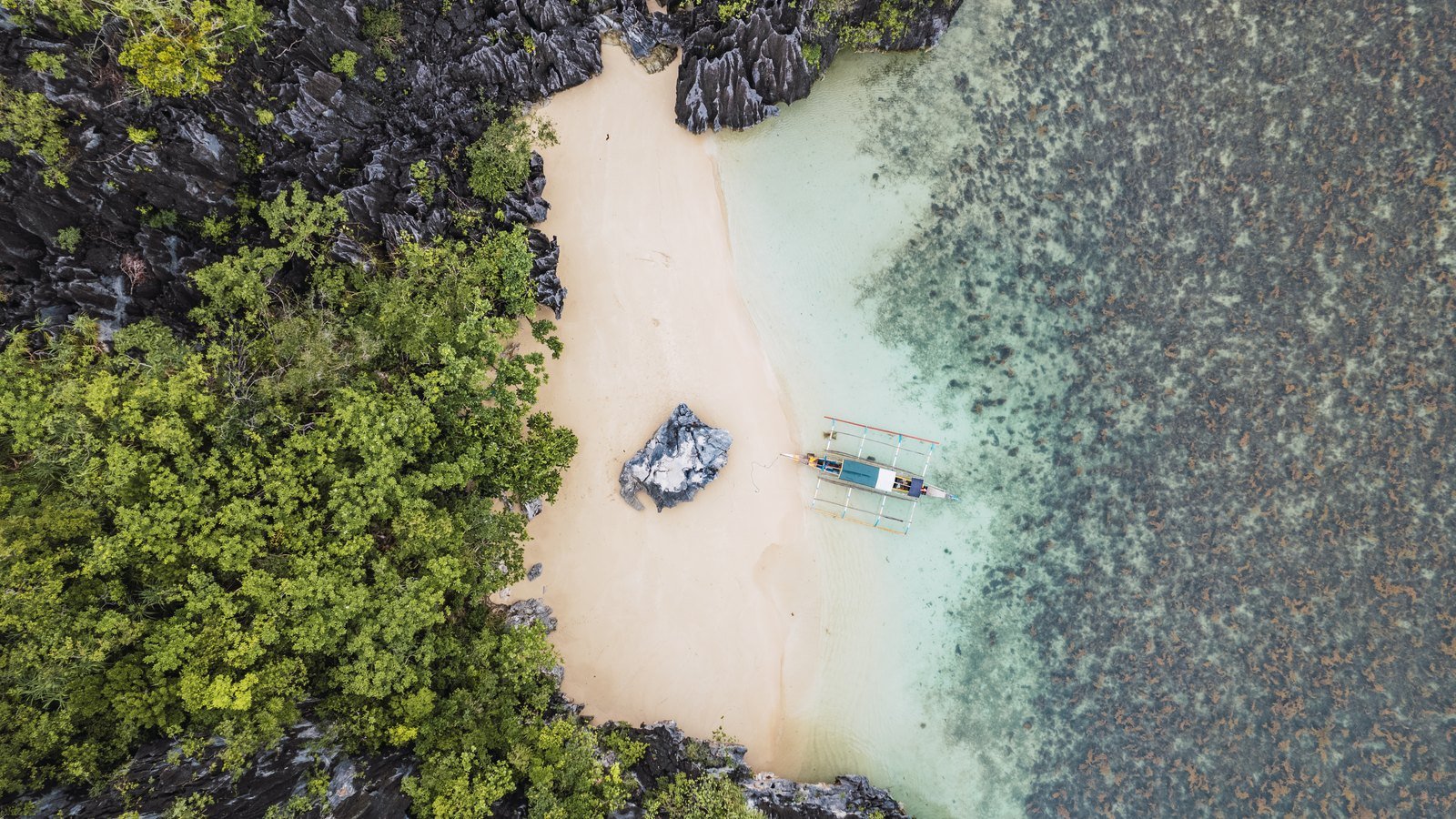 Secluded beach framed by limestone cliffs and dense greenery