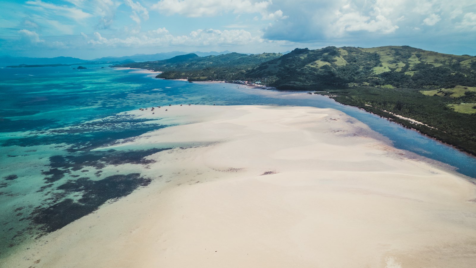 Coastline of Camarines Sur with green hills meeting clear water